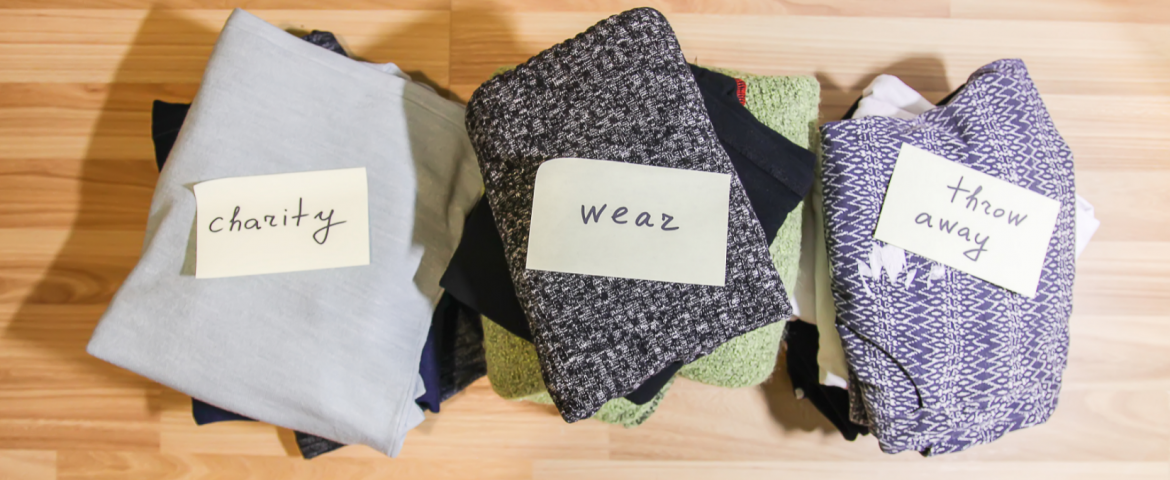 Three piles of clothing to keep, throw away and donate