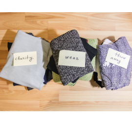 Three piles of clothing to keep, throw away and donate