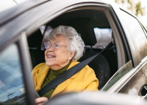 Senior lady driving her car and smiling