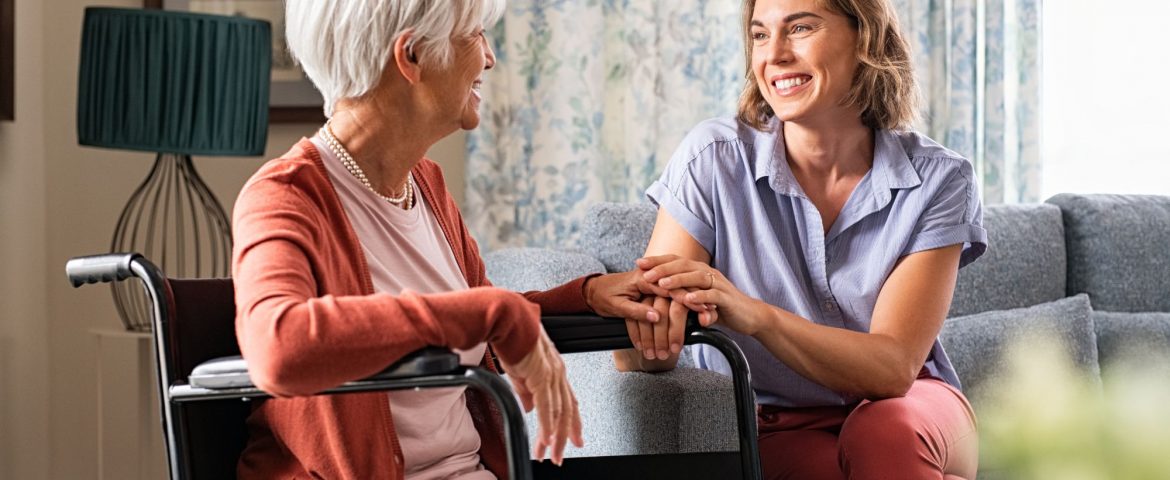 Mother in wheelchair with daughter holding her hand in living room